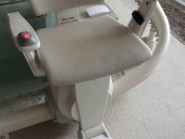 Beiger Sitz mit Armlehne an einem Gehstuhl.