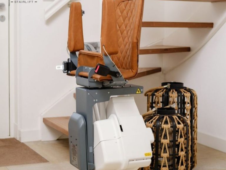 Treppenlift mit braunem Sitz und beige-weißer Basis vor einer Treppe.